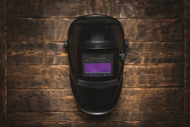 Welding helmet background. Welding mask on the wooden workbench background flat lay. welding mask stock pictures, royalty-free photos & images