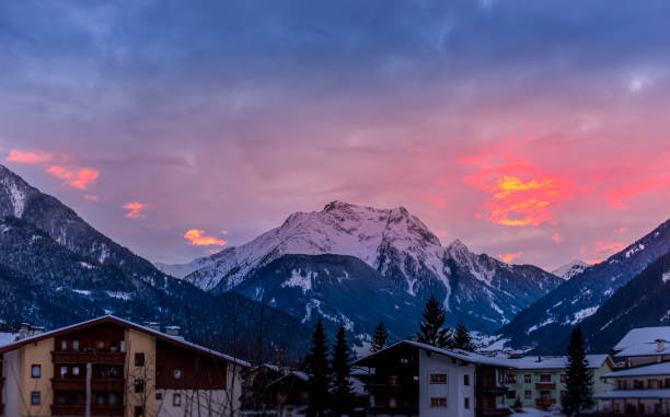 istock Unfocused ski lodge below a stunning sunset with snowcapped mountains 1296907266