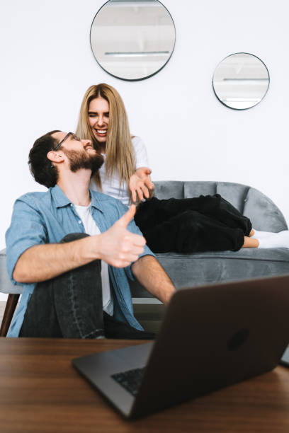 istock Young couple using laptop computer and resting on the sofa at home together. 1296910652