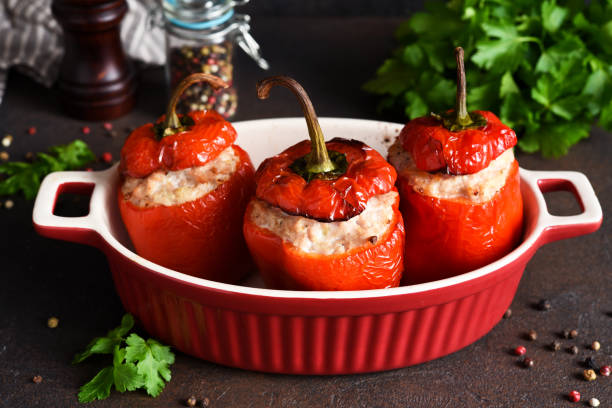 istock Stuffed peppers baked with meat and rice on a dark concrete background 1296910836