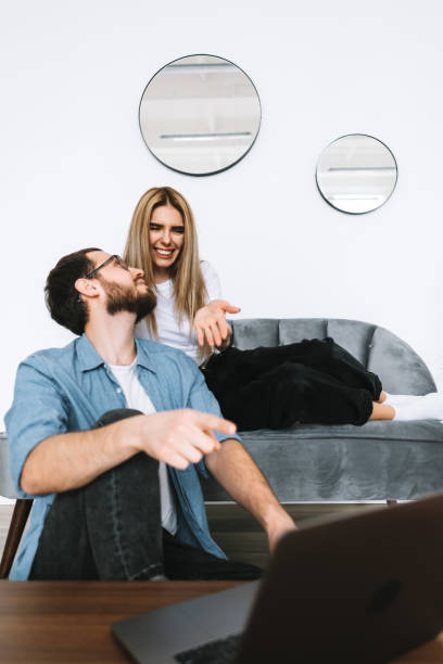 istock Young couple using laptop computer and resting on the sofa at home together. 1296911099