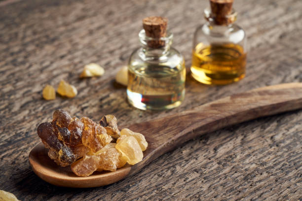 frankincense resin crystals on a spoon, with essential oil bottles - tree resin imagens e fotografias de stock