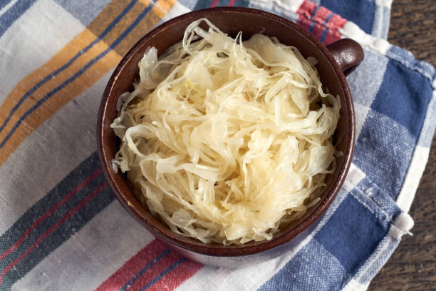 istock Fermented cabbage in a pot on a striped dish towel 1296911941