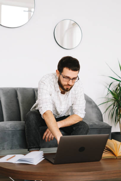 istock Young caucasian businessman work at home, freelance work, use laptop computer. 1296912428