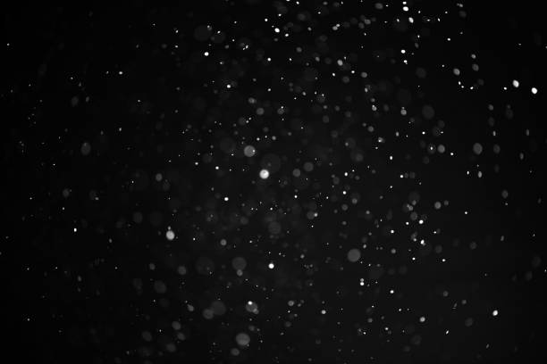 istock texture of falling snow, layer to overlay on a black background 1296915817