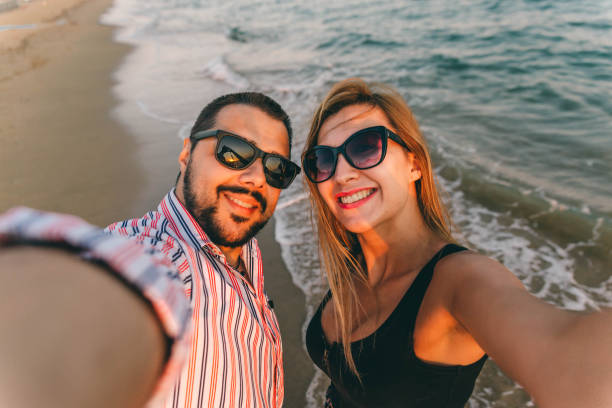 istock Couple taking selfies at the beach 1296918975
