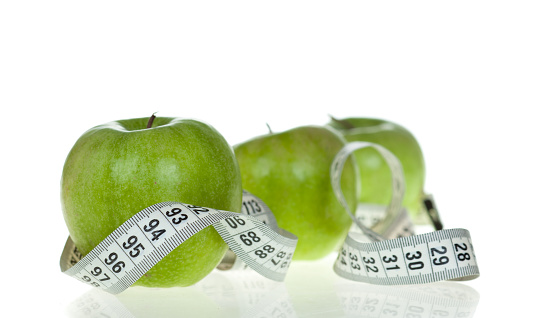 Apple with measurement tool isolated on white