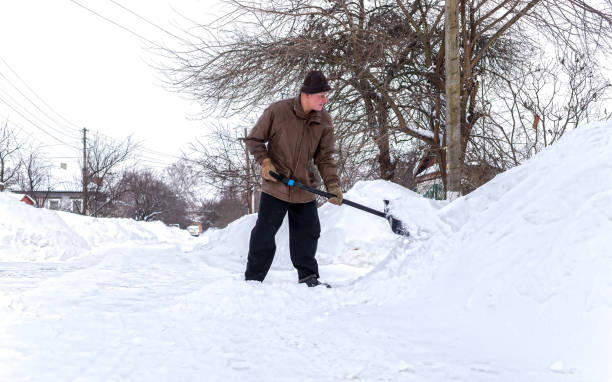 istock Man with a shovel cleans the track from the snow 1296920187