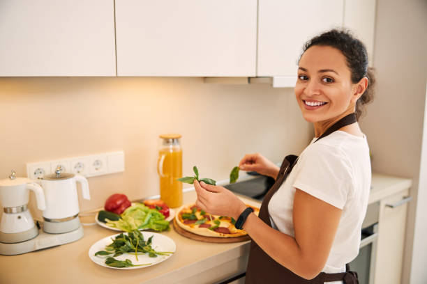 istock Contented lady following the recipe and smiling while cooking 1296921613