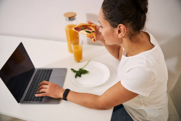 istock Relaxed lady eating at home and chatting online 1296921632