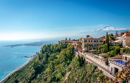 A view of Taormina, Mount Etna and the Ionian Sea as seen from Piazza IX Aprile. In Sicily, Italy.