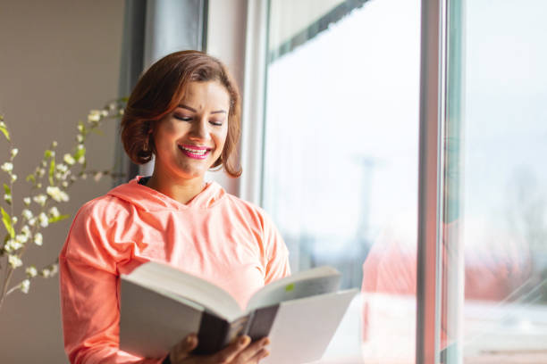 istock Generation Z Female in Home Office Setting reading a Book 1296923819