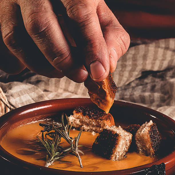 istock hand dipping bread in a pumpkin cream 1296926992
