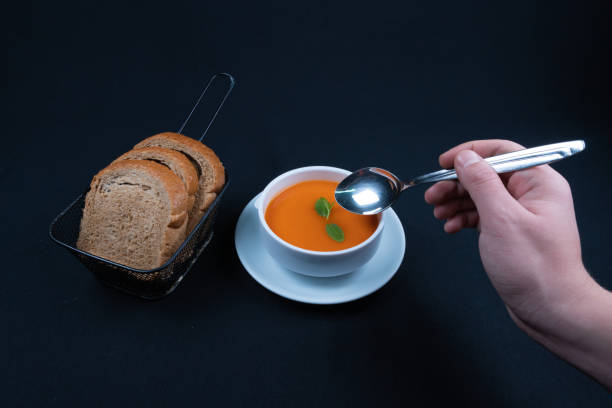 istock Tomato soup with basil in a bowl. Dark background. 1296929022