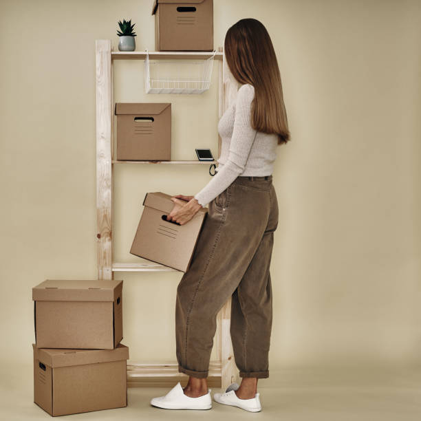the girl makes up paper boxes on a wooden rack. eco-friendly storage and packaging - 16019 imagens e fotografias de stock
