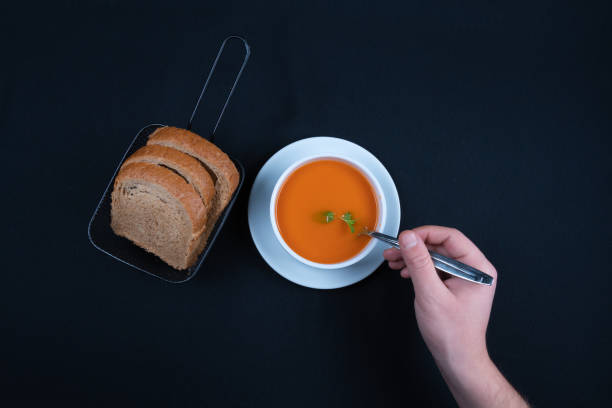 istock Tomato soup with basil in a bowl. Dark background. 1296934182