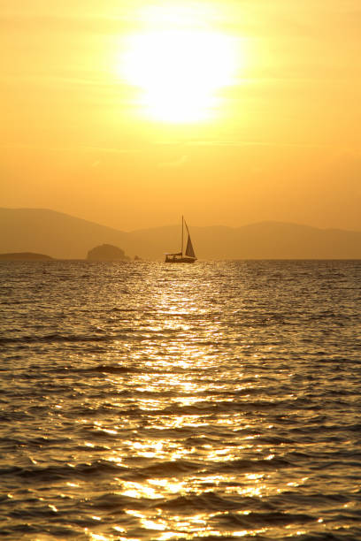 istock Alone sailboat at sunset. Atmospheric seascape with orange sun. 1296936423