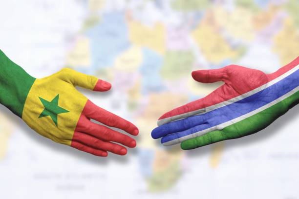 istock Senegal and Gambia - Flag handshake symbolizing partnership and cooperation 1296943130