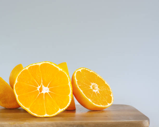 istock Piece of orange on cutting board 1296947581