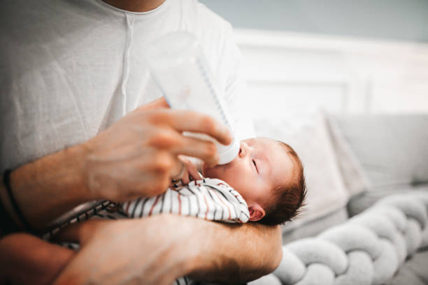 istock Father feeding newborn baby 1296949813