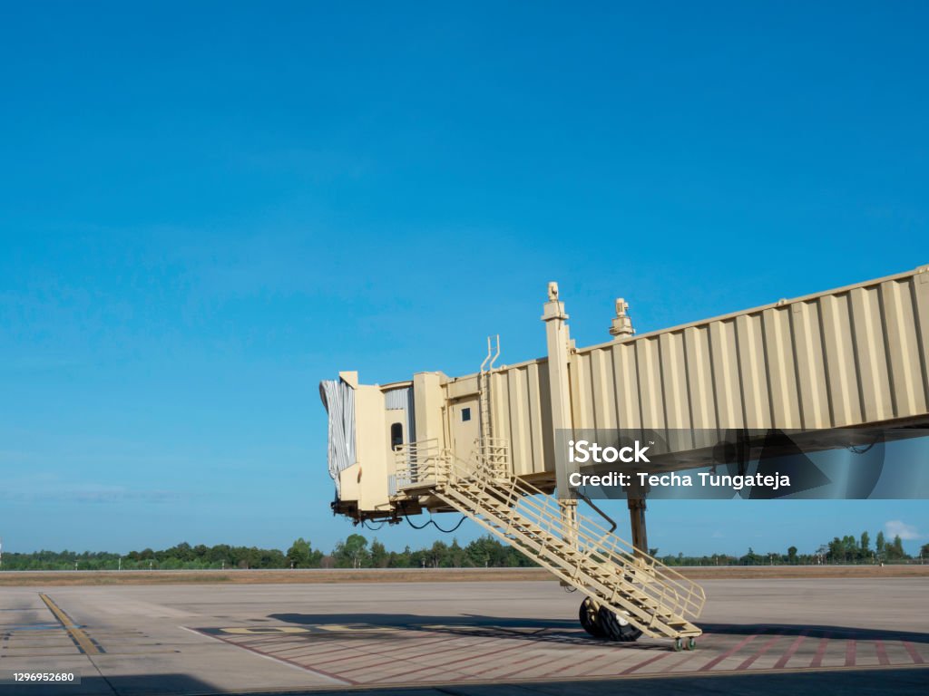 Jetway with no airplane in airport. Jetway with no airplane in airport on blue sky background with copy space. Air bridge for passenger in the airport. Passenger Boarding Bridge Stock Photo