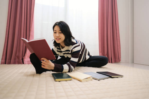 istock Woman reading book with doing exercise in room 1296953254