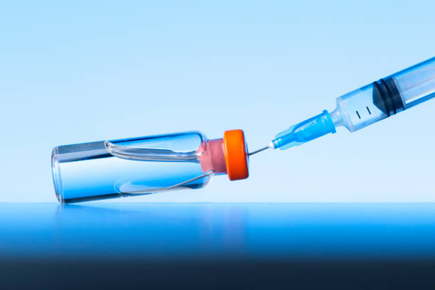 istock Vial and Syringe on Blue Background with Copy Space. Vaccination and immunization. 1296955147