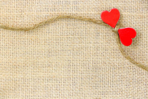 istock Small bow rope sack with pair red heart paper on brown sack background have copy space for put text 1296955927