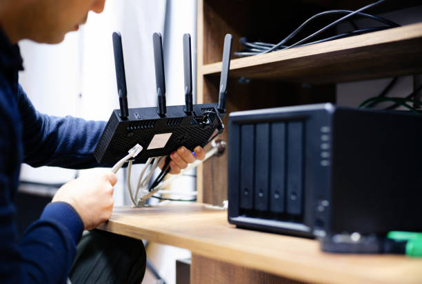 ネットワーク接続ストレージ システム用のケーブルを準備する男性、自宅または小規模企業での nas の使用の概念 - computer network server repairing technology ストックフォトと画像