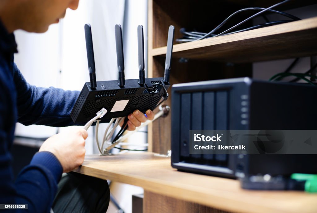 Man Preparing Cables For For Network Attached Storage System, Concept For NAS Usage At Home Or At Small Businesses Router Stock Photo