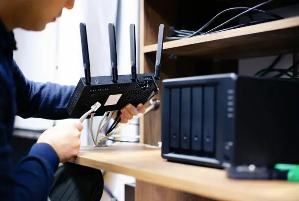 Photo of Man Preparing Cables For For Network Attached Storage System, Concept For NAS Usage At Home Or At Small Businesses