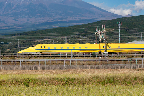 Japan - November 15. 2019 : High Speed Bullet Train Doctor Yellow Shinkansen  on railway with Fuji Mountain Background, Fuji, Shizuoka