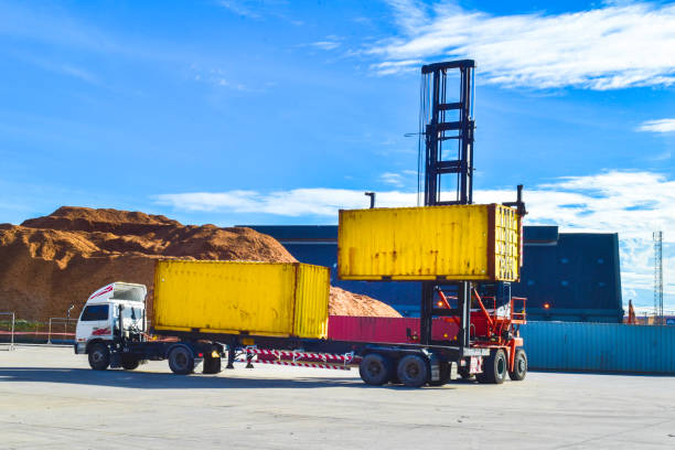 istock Top lift unload container from trailer. Container handling, transportation, and shipping. 1296961961