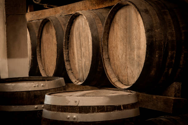Wine barrels stacked in the old cellar of the winery. stock photo