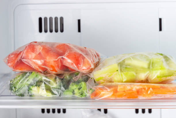 istock Frozen vegetables in bags in freezer close-up, front view 1296964034