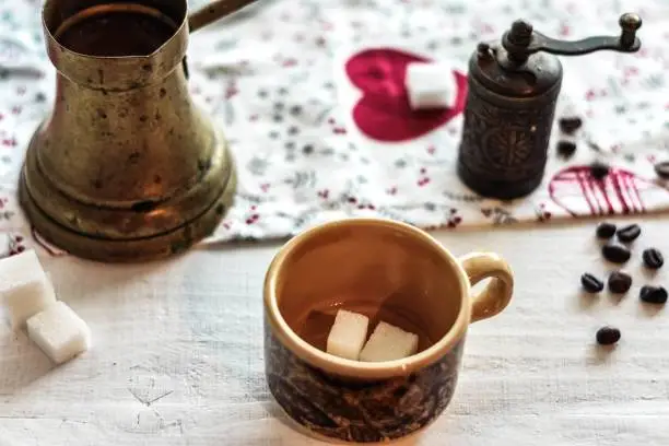 Traditional black strong Turkish coffee served whit sugar cubes and roasted coffee beans