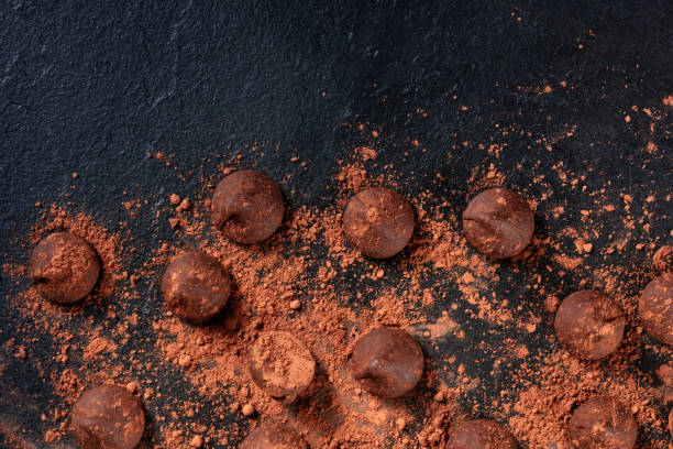 Chocolate truffles, shot from above on a black background Chocolate truffles, shot from above on a black background with a place for text chocolate truffle making stock pictures, royalty-free photos & images