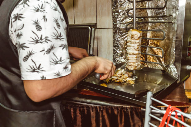 istock Cook cooking shawarma kebab meat on a spit arabic spicy sauce 1296972181