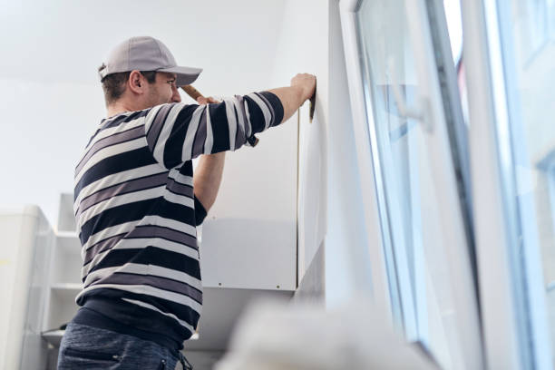 istock Handyman worker making hole for airduct ventilation in the kitchen. 1296974107