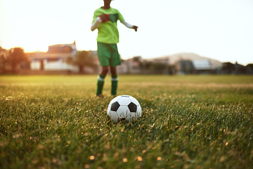 Closeup shot of a young boy playing soccer on a sports field