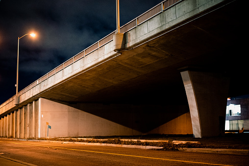 Complementary colours and interestingly shaped shadows under street overpass at night in west Toronto.