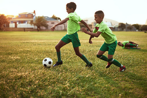 Shot of a group of young boys playing soccer on a sports field