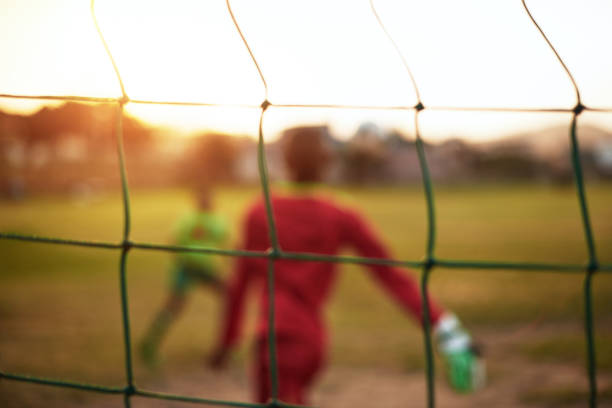 Defocused shot of young boys playing soccer on a sports field