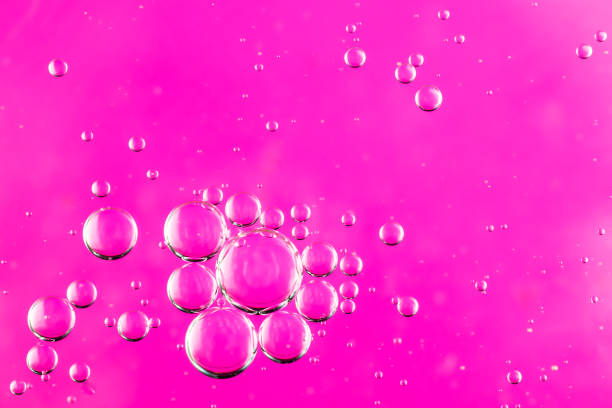 istock oil drops on water on a pink background 1296977802