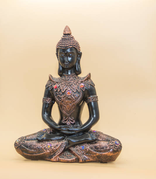 istock a small image of buddha in lotus position isolated on light background 1296978656