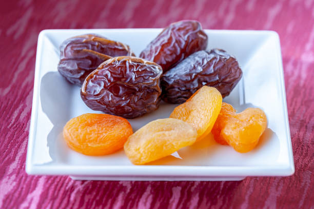 Plenty of dates and apricot arranged in a white bowl
