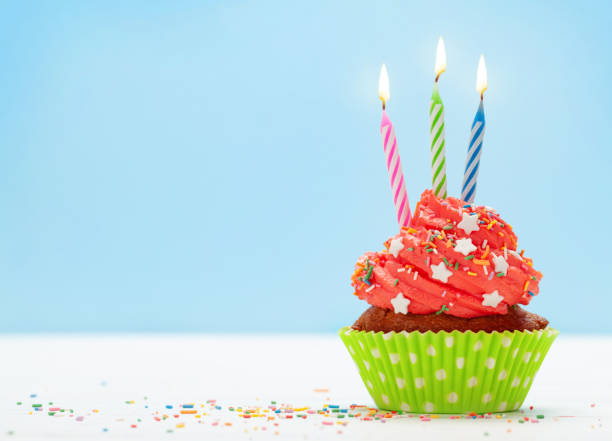 istock Birthday cupcake with burning candle 1296979793