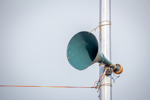 Un altavoz adjunto al poste de la lámpara a lo largo de la playa de Marina para anuncios públicos, Chennai, India photo