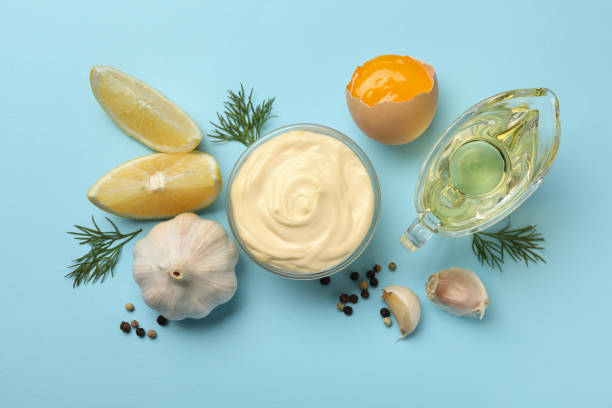 istock Bowl with mayonnaise and ingredients on blue background 1296980329