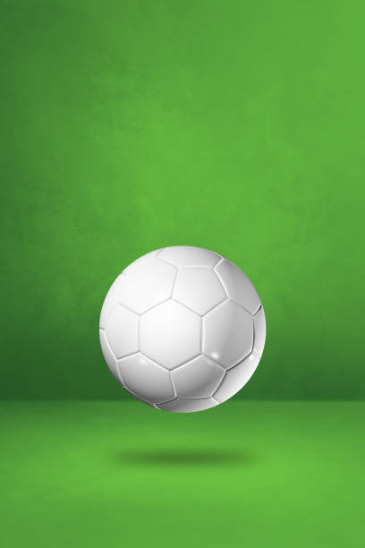 istock White soccer ball on a green studio background 1296981448
